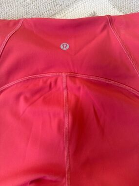 Lululemon Raspberry colored Athletic Leggings with net fabric around bottom leg.